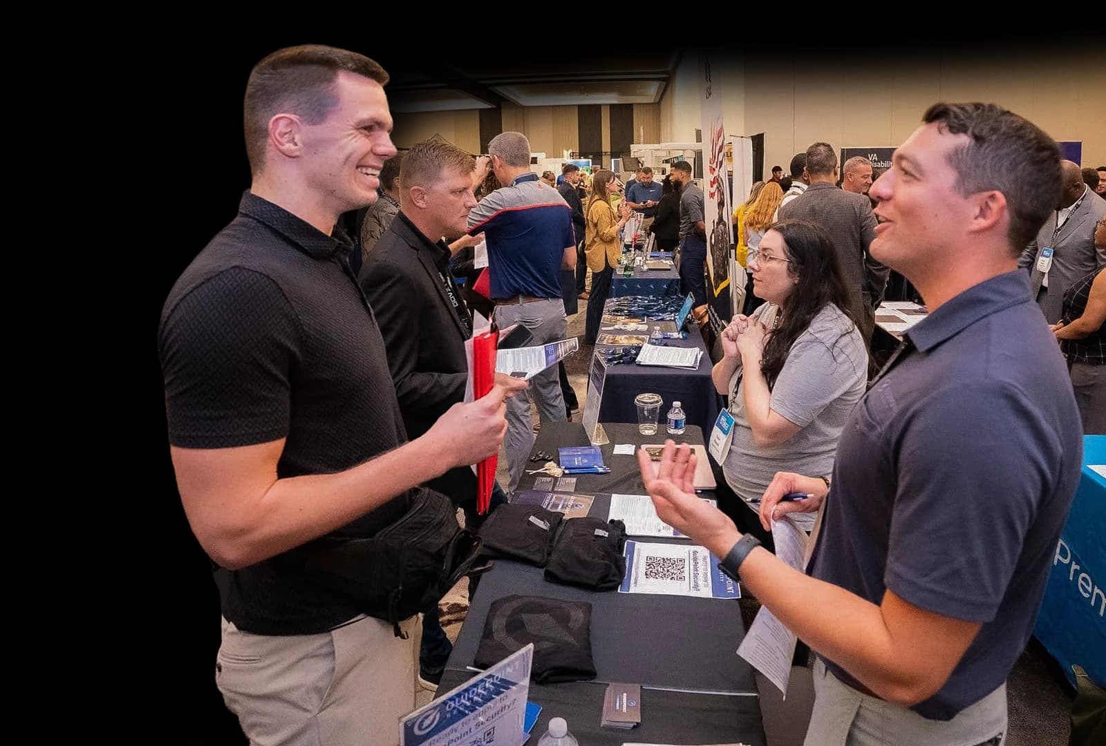 Attendees networking at a Marketplace booth during the Military Impact Conference